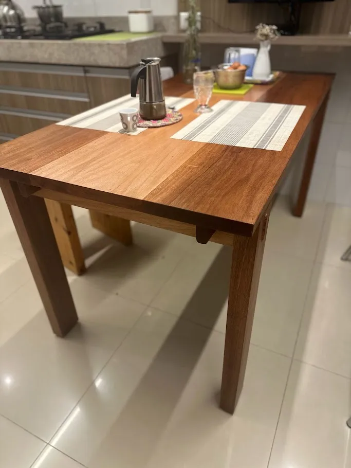 Mesa de cozinha em madeira maciça com quatro pernas e cavilhas aparentes nas travessas, posta com jogo americano e cafeteira italiana. — foto 2